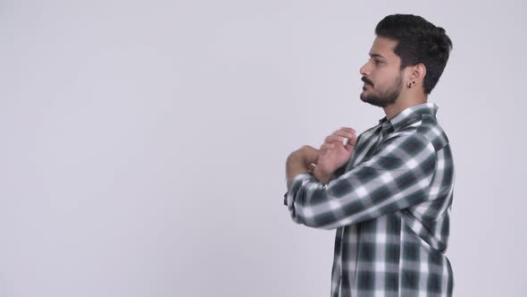 Profile View of Young Handsome Bearded Indian Man Looking at Camera alt