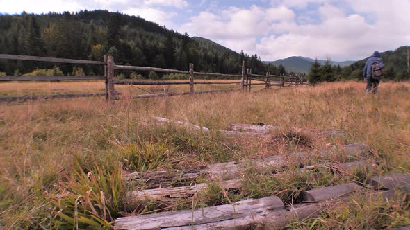 Agriculture concept. Man in green work boots going forward and returning back. alt