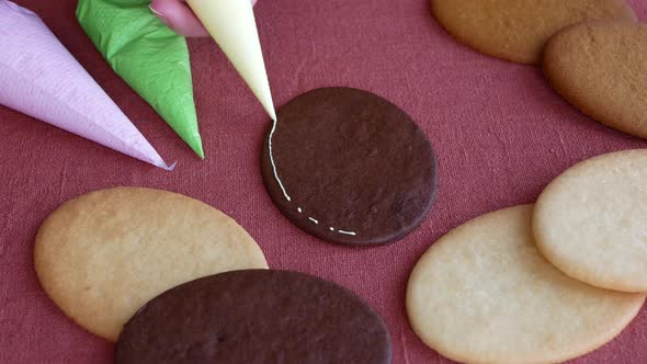 Process of gingerbread decoration using colored sugar icing. Decorating cookies, close up