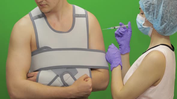 Man with Shoulder Injury. Nurse Makes Prick From Pain. Bandage Fixing Shoulder alt