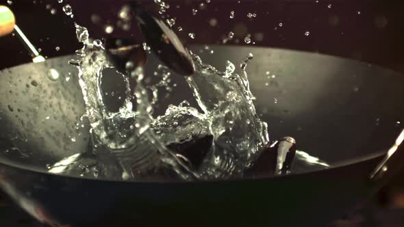Super Slow Motion Mussels Fall Into a Pan with Water Spray alt