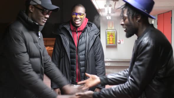 three african men standing in the street and having conversation alt