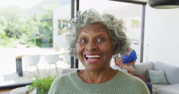 Portrait of happy senior african american woman with other seniors at retirement home alt