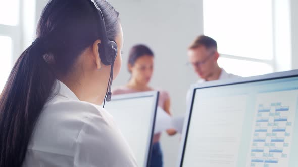 Diverse team of young professionals is working in the phone support office. alt