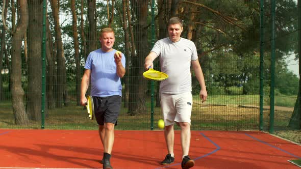 Cheerful Male Tennis Players Going To Tennis Court alt
