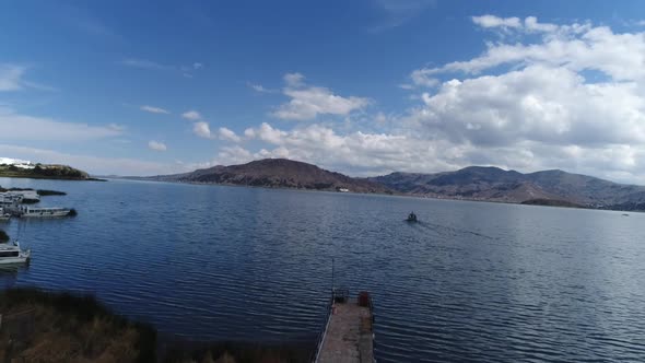 drone movement in the city of Puno on a beautiful sunny day over Titicaca lake, Peru alt