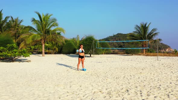 Young smiling girls on holiday in the sun at the beach on summer white sandy and blue background 4K alt