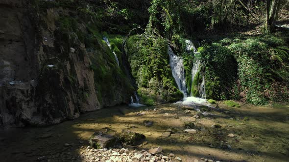 Aerial Shot of Beautiful Waterfall Among Green Trees in Forest