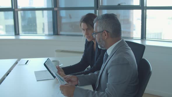 Project Manager and CEO Discussing and Analyzing Reports alt