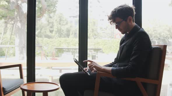 Businessman in suit wearing glasses use tablet to check email online and learning and reading news alt