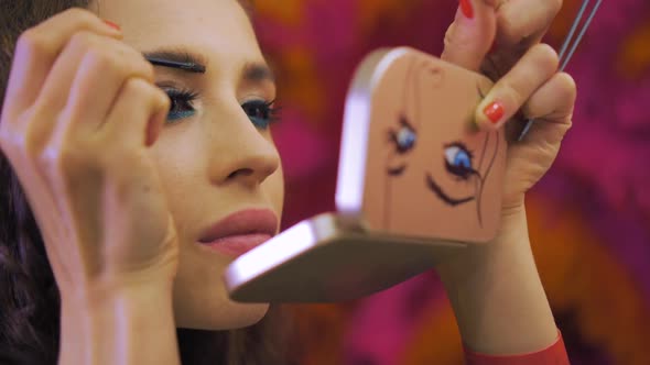 Young Woman Paints the Eyebrows with Pocket Mirror
