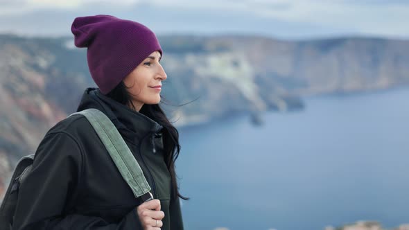 Adorable Active Backpacker Woman Walking on Top of High Mountain Over Sea at Windy Weather Closeup alt