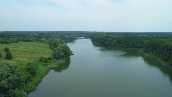 Aerial View Beautiful Nature Forest and Lake in Which Fisherman is Fishing alt