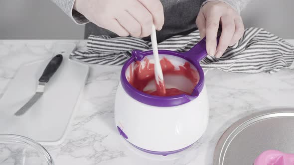 Step by step. Melting red chocolate chips for chocolate molded shapes. alt