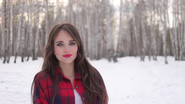 Charming Female with Long Hair Walking in Snowy Forest