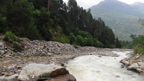 Narrow River with Fast Water Streams Runs Down Among Rocks
