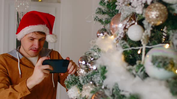 Man Taking Picture of Christmas Tree alt