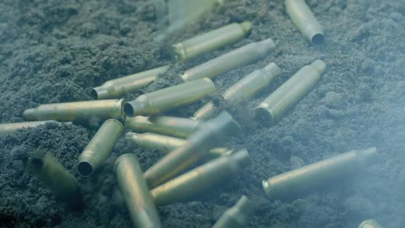 Bullet Cases Hit The Ground With Muzzle Flashes And Smoke alt