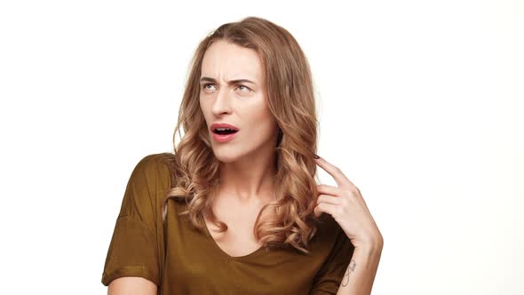 Displeased Beautiful Middleaged Female with Long Brown Hair Looking at Camera Gesturing on White alt