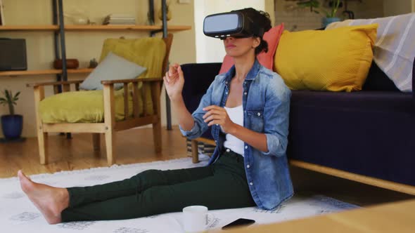 Smiling caucasian woman wearing vr headset, sitting on floor at home alt