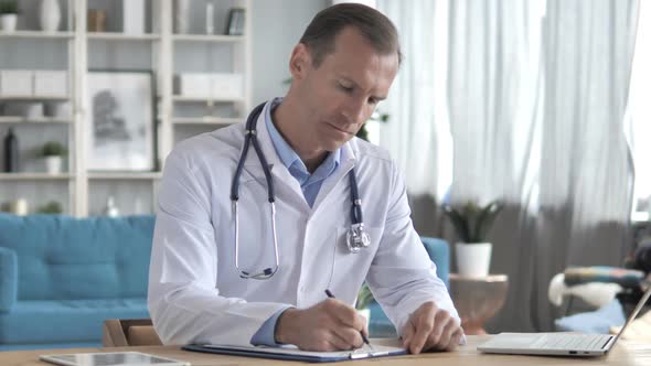Senior Doctor Writing Medical Documents Prescription for Patient alt