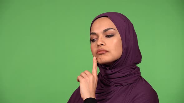 A Young Beautiful Muslim Woman Thinks About Something  Closeup  Green Screen Background