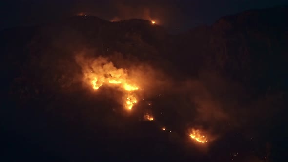 High-ISO aerial view of wildfire in the mountains.