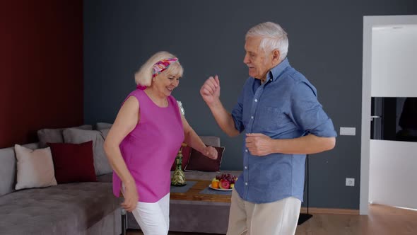 Senior Mature Couple Dancing Together in Room at Home During Quarantine Lockdown for Coronavirus alt