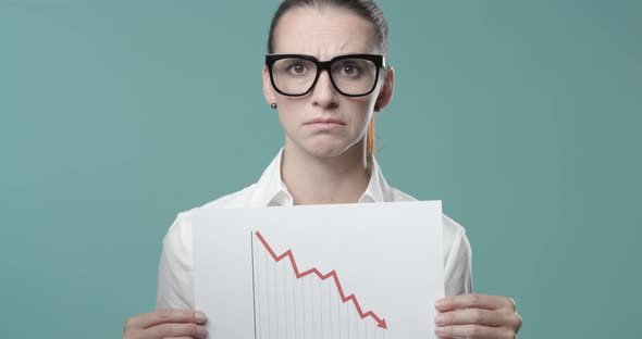Businesswoman holding a negative financial chart
