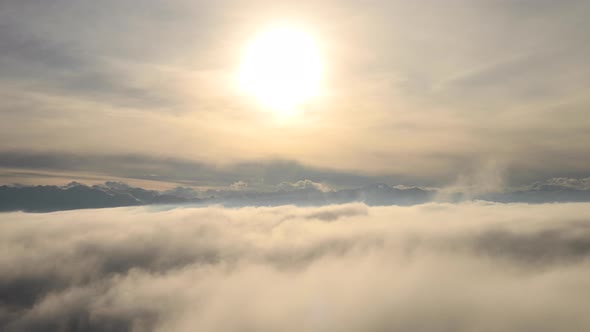 Incredible Aerial View Shot Above Swirling Fog and Clouds at Sunset in the Mountains alt