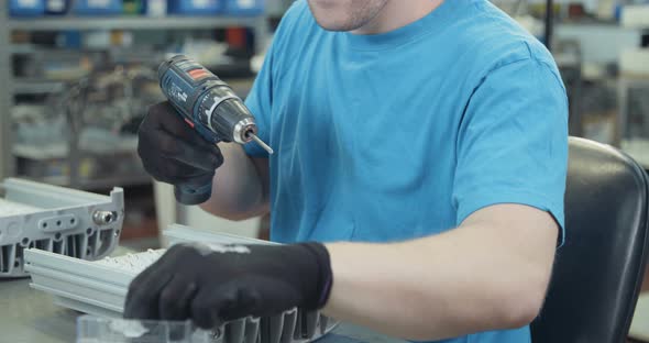 Worker testing LED lamp in an advanced electronics manufacturing facility alt