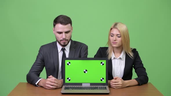 Young Happy Business Couple Showing Laptop Together