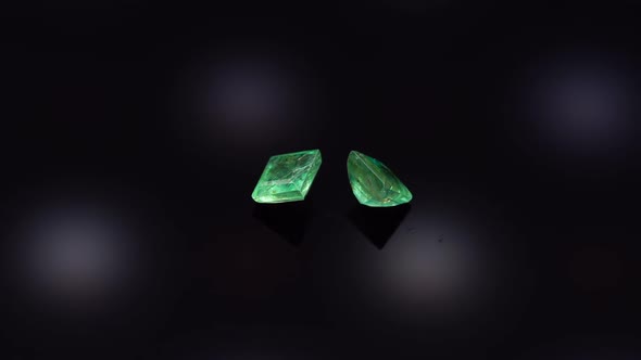 Natural Green Emerald on the Turning Table on the Black Background