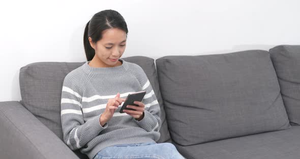 Woman using mobile phone at home alt
