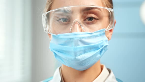 Concentrated lady doctor in blue disposable facial mask alt