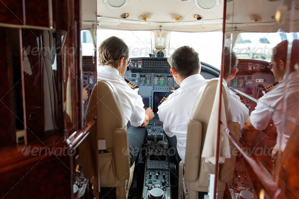 Pilots Operating Controls Of Private Jet - Stock Photo - Images