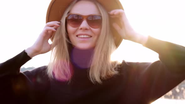 Caucasian Blonde Woman with Beige Hat in Black Sweater Wear Sunglasses in the Countryside alt