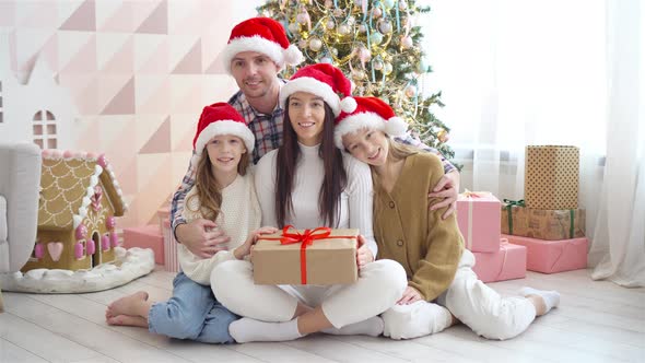 Happy Young Family with Kids Holding Christmas Presents