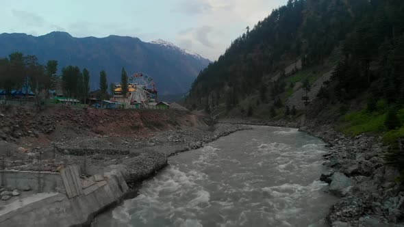 Aerial Over Swat River With Ferris Wheel In Background In Kalam, Pakistan. Dolly Forward alt