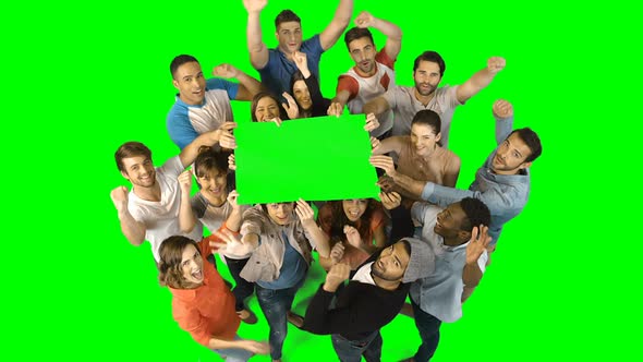 Excited business executives holding green placard alt