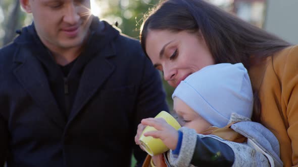 Man and Women Enjoy Parenting and Hold Their Little Male Child in Their Arms During Family Fun in