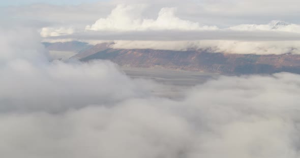 Aerial overhead wide shot of hillside over trees, following river drone footage alt