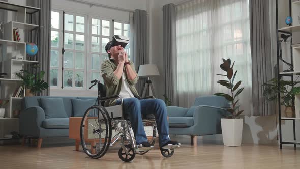 Scary Asian Man Sitting In A Wheelchair While Wearing Virtual Reality Goggles Watching Horror Movie alt