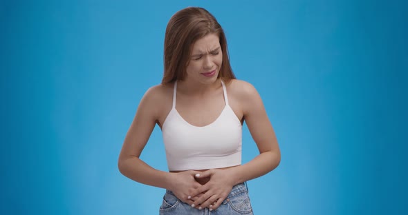 Young Woman Experiencing Stomach Pain, Suffering From Severe Pain and Cramp in Lower Abdomen alt