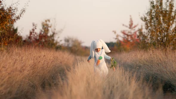 Adorable 3Years Boy in White Bunny Costume with Carrot Running to Camera on Autumn Background alt