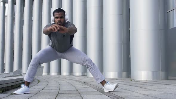 Concentrated Sportsman Doing the Lateral Lunge to Prepare Hamstring Muscles alt