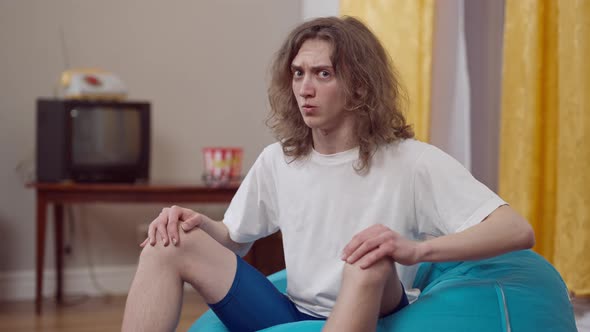 Funny Curlyhaired Young Retro Man Grimacing with Surprised Facial Expression Looking at Camera alt