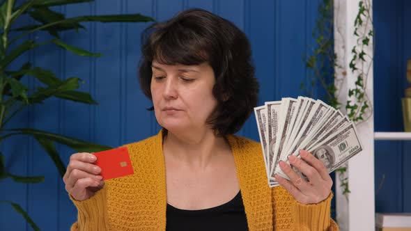 Middle Aged Woman is Holding Credit Card and Money and Can't Choose
