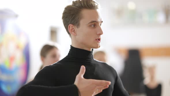 Side View of Confident Male Dance Teacher Explaining Dance To Children and Teens in Dancing School alt