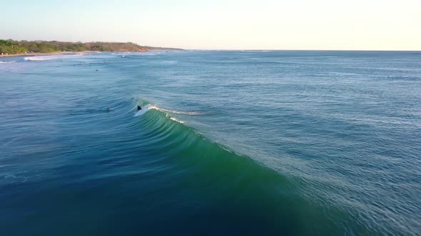 Surfer catching a wave in costa rica aerial alt